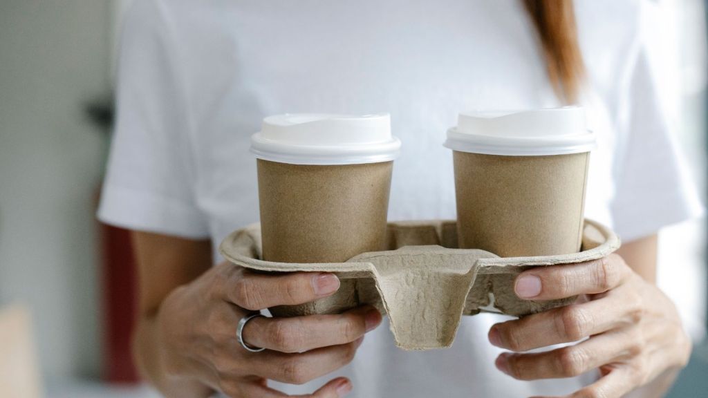 Woman carrying a platter of coffee to-go