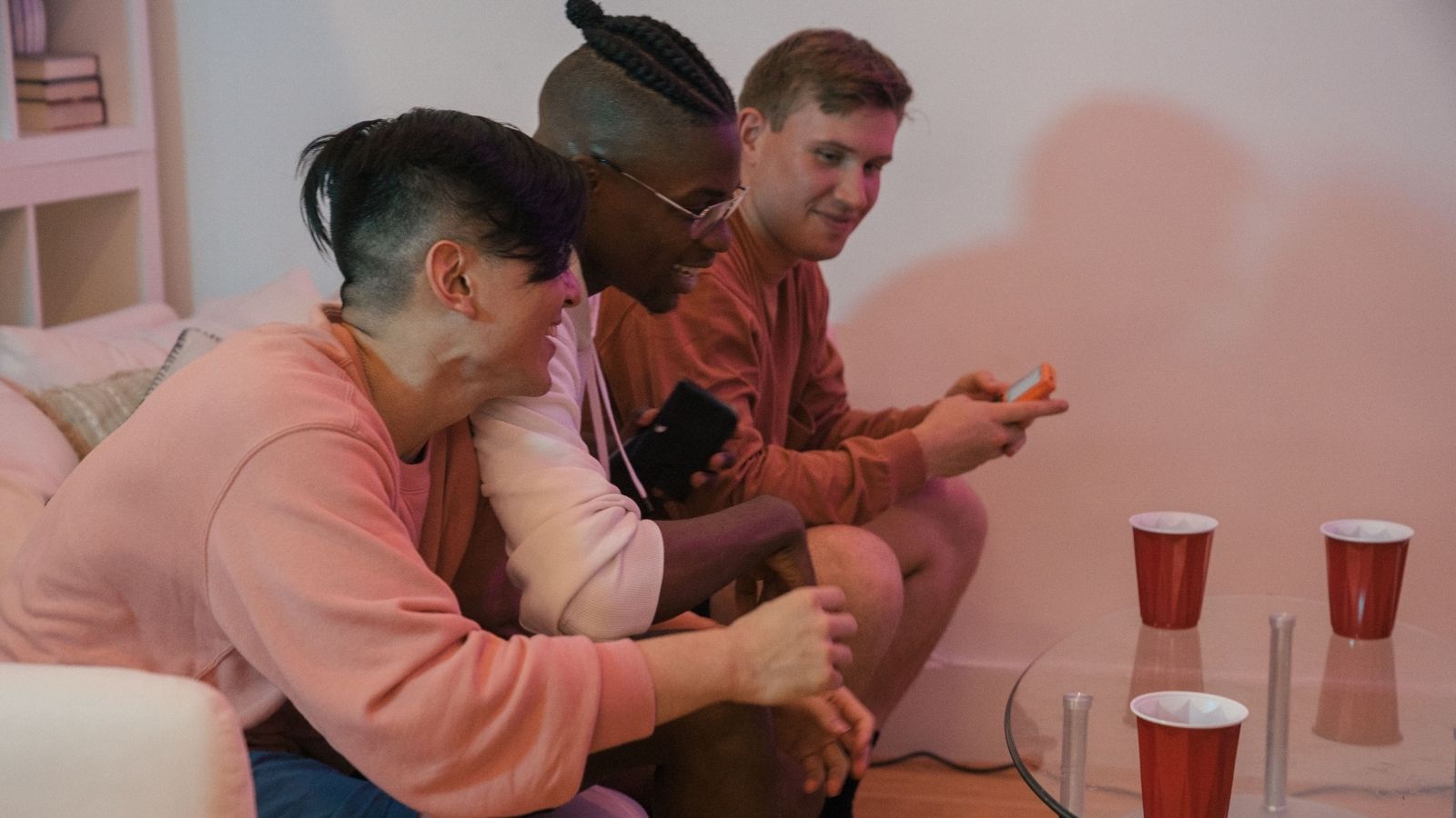 Three frat boys playing video games on the couch
