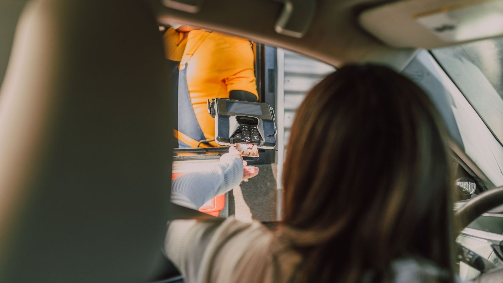 She Demanded a Full Breakdown of Why Her Drive Thru Order Came to Exactly $19.73—Then Stared in Silence When the Worker Neutralized Her Outrage with a Single Word Man holding card reader out the drive thru