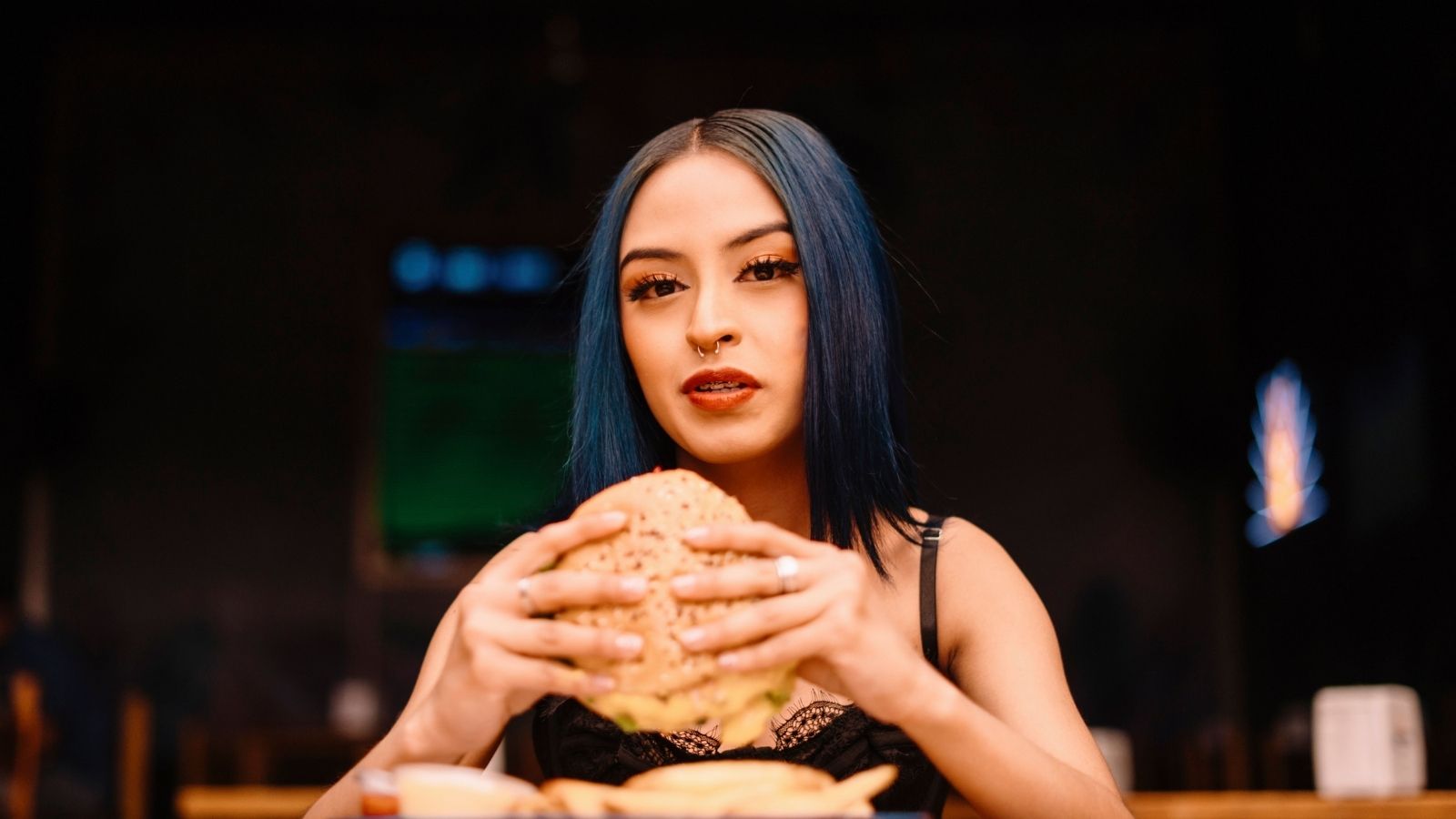 Woman eating burger at a casual restaurant