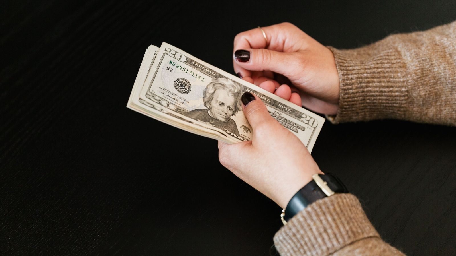 Woman counting cash from her register