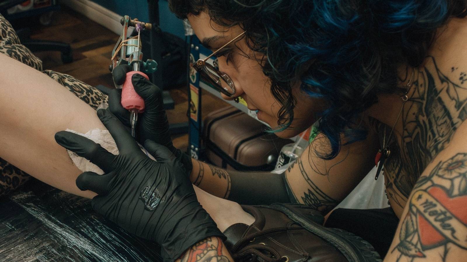 She Dropped a $250 Tip for Flawless Speed and Skill—Then Her Friend Called Her an Absolute Idiot for Tipping Over 20% Woman tattooing someone's leg