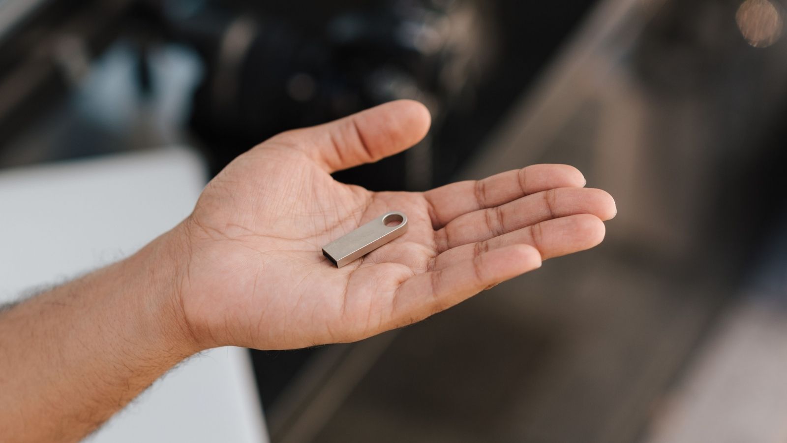 A Big Box Tech Desk Demanded $300 to Send Her Flash Drive to a Clean Room Lab—Then an Independent Tech Fixed It with a $5 Adapter in 10 Minutes Man holding a USB in his hand