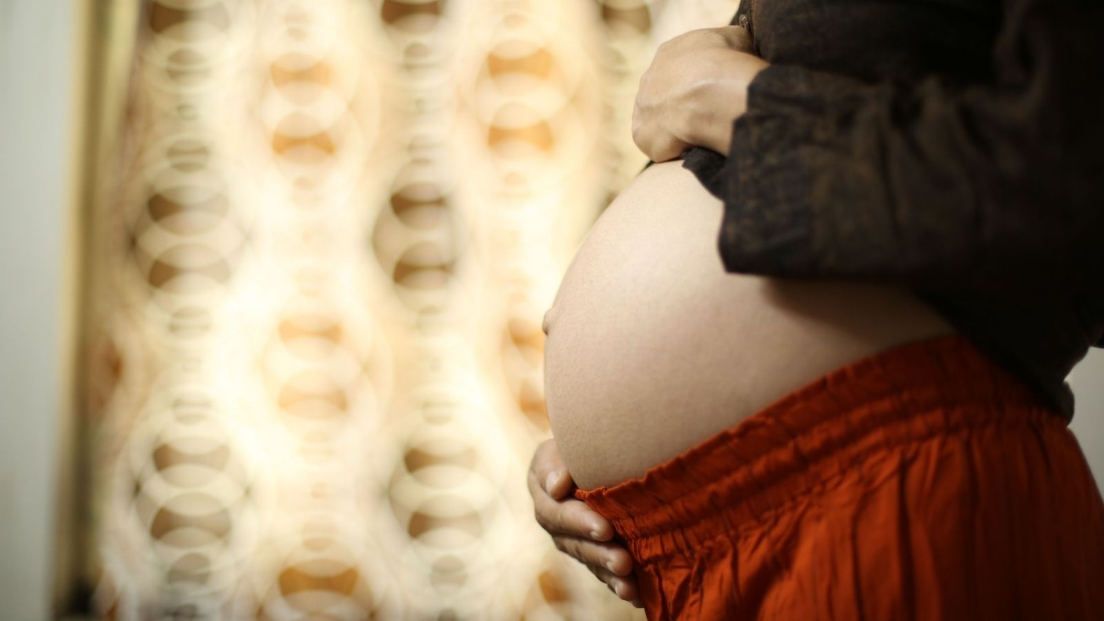 Woman holding her very pregnant stomach