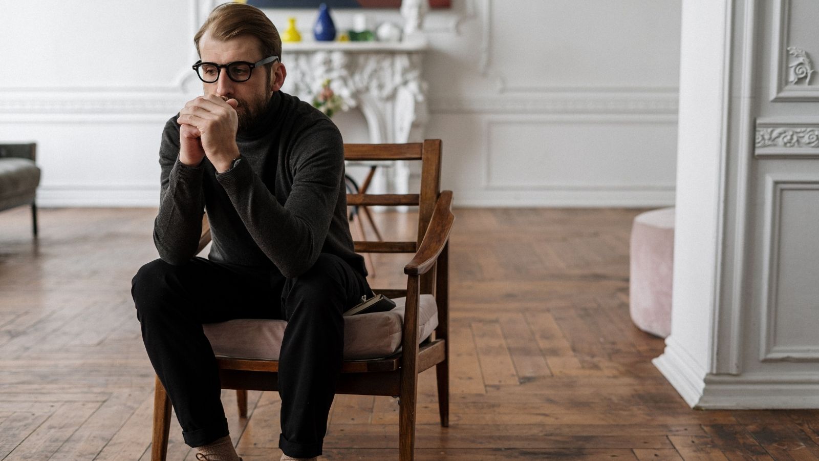 Man sitting in a chair thinking about his options. 