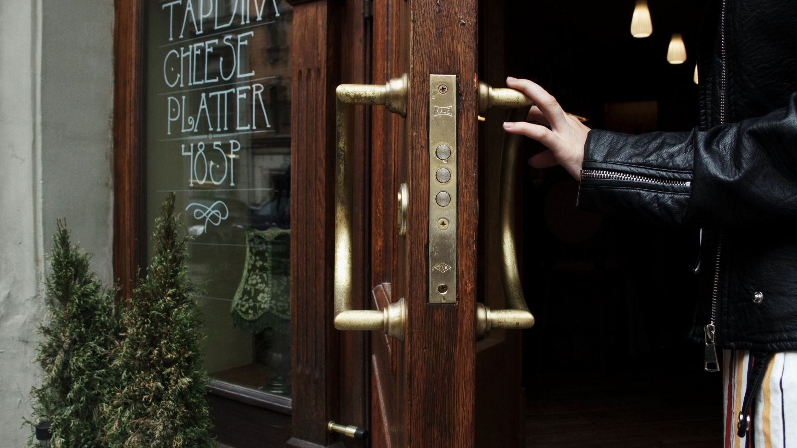 Person holding a door open as they enter