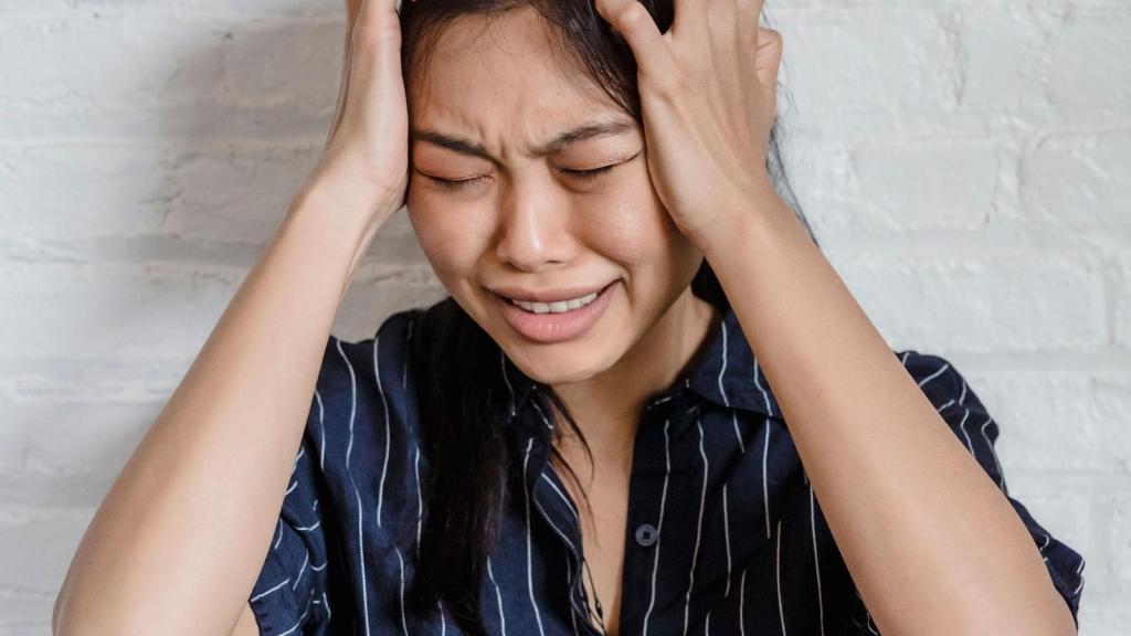 distressed woman covering her ears