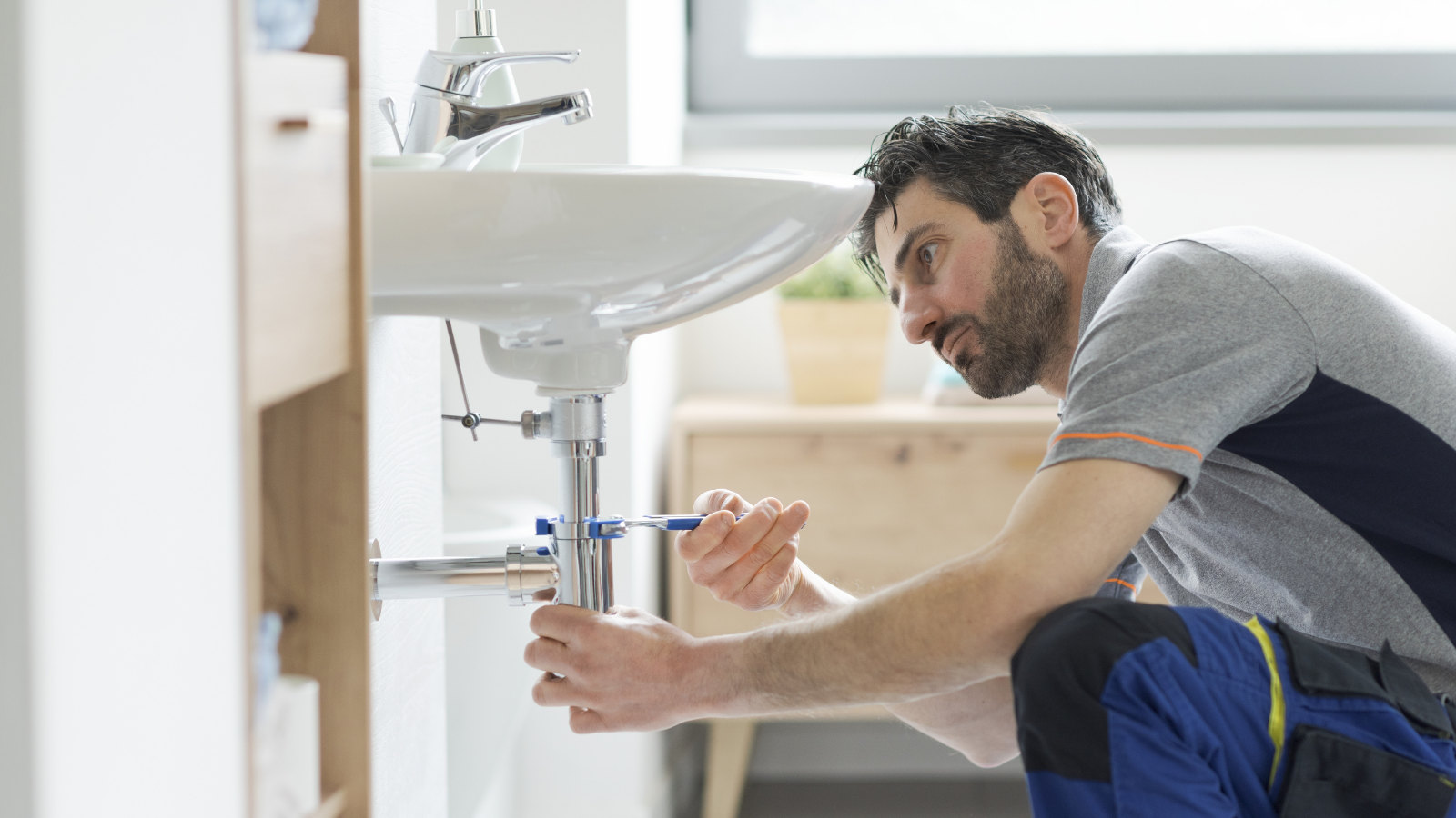 He Just Needed a Plumber for an Emergency — Instead, the HOA Secretary Barged Into His Home Uninvited plumber fixing a sink