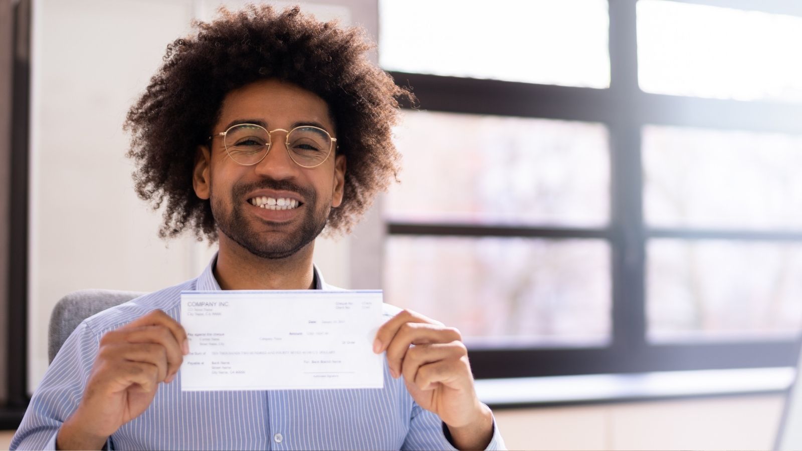 His Landlord Tried To Withhold A Cleaning Fee From His Deposit — So He Went To The Sheriff To Get It All Back smiling man holding a check