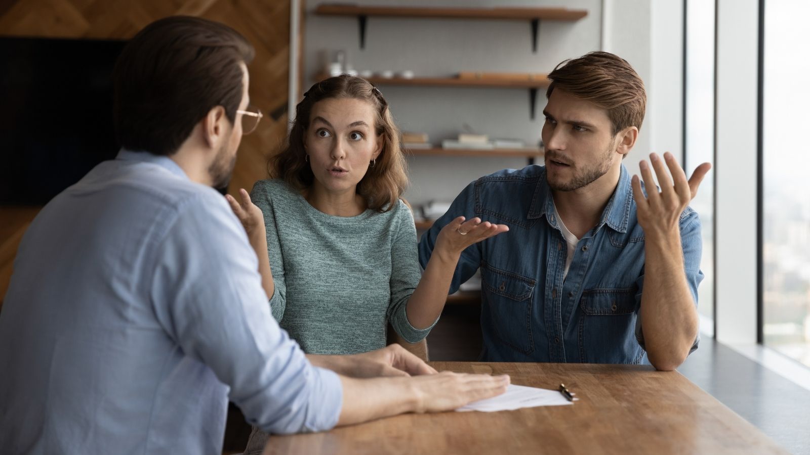 He Invested $18,000 in Capital Repairs Under a Rent to Own Promise—Then Received a Notice of Rent Increase unhappy couple in a real estate meeting