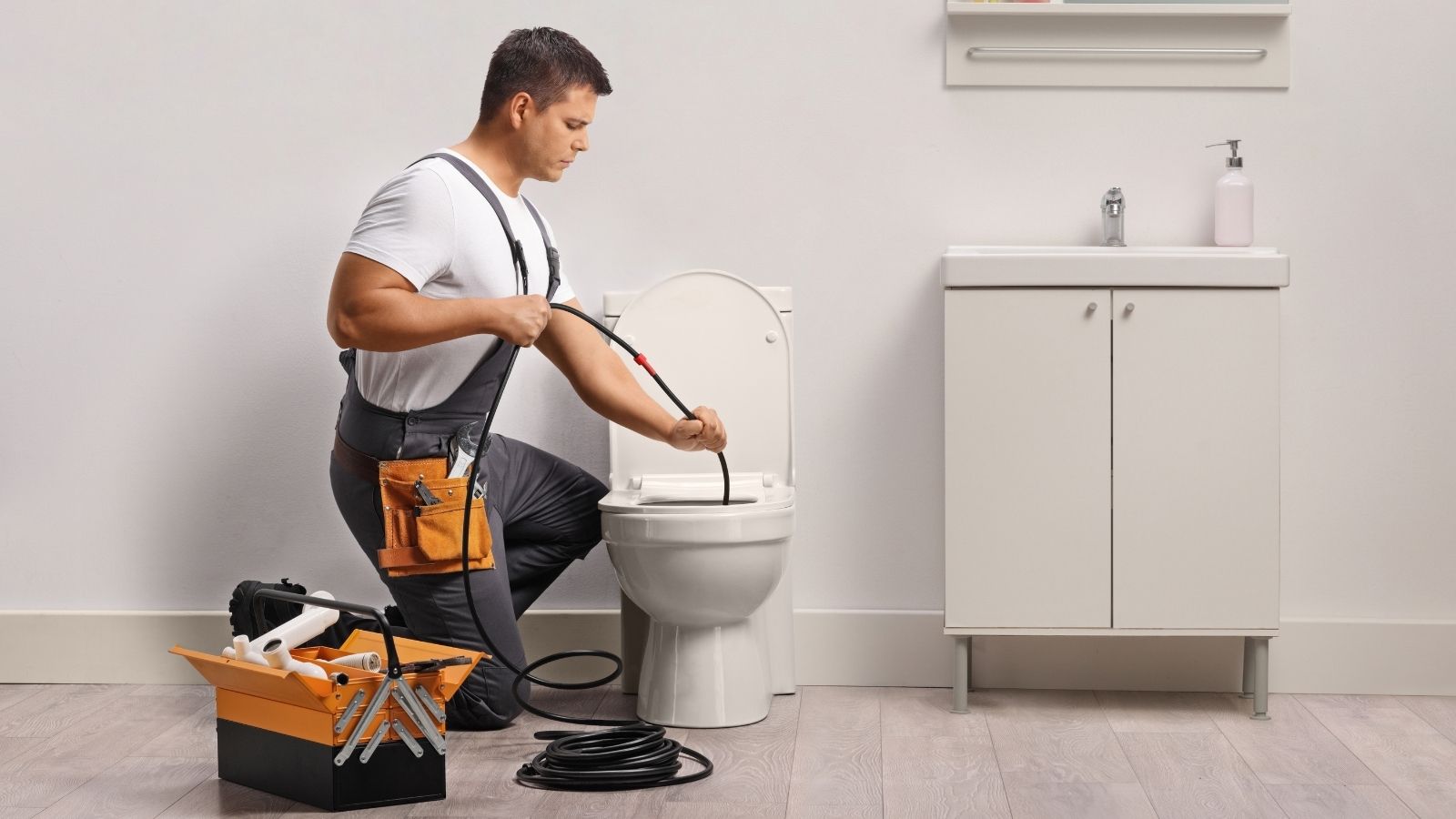 A Plumber Found Something In The Toilet That Should Never Have Been Flushed — Now The Landlord Wants The Tenant To Pay plumber snaking a toilet