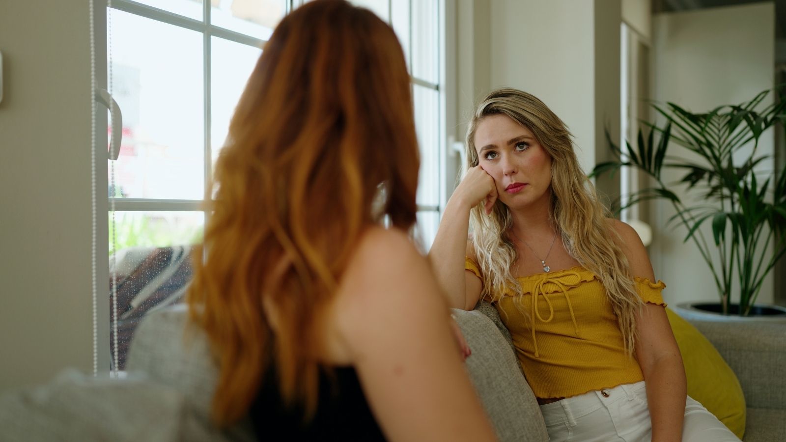 woman looking bored while listening to her friend