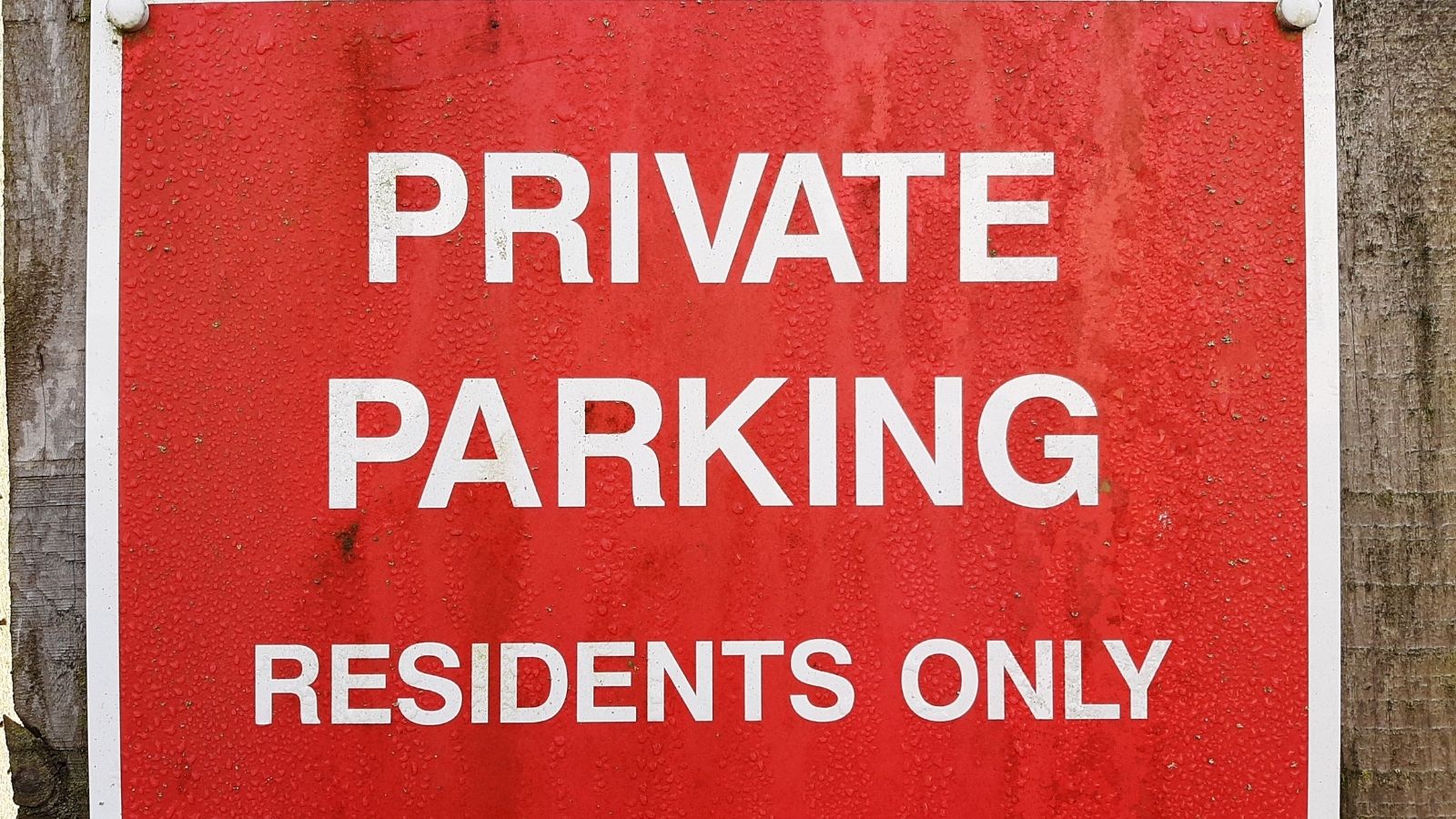 She Left A Note On The Car Parked In Her Private Spot — The Driver Yelled Awful Things At Her Husband red sign with white letters that reads "private parking residents only"