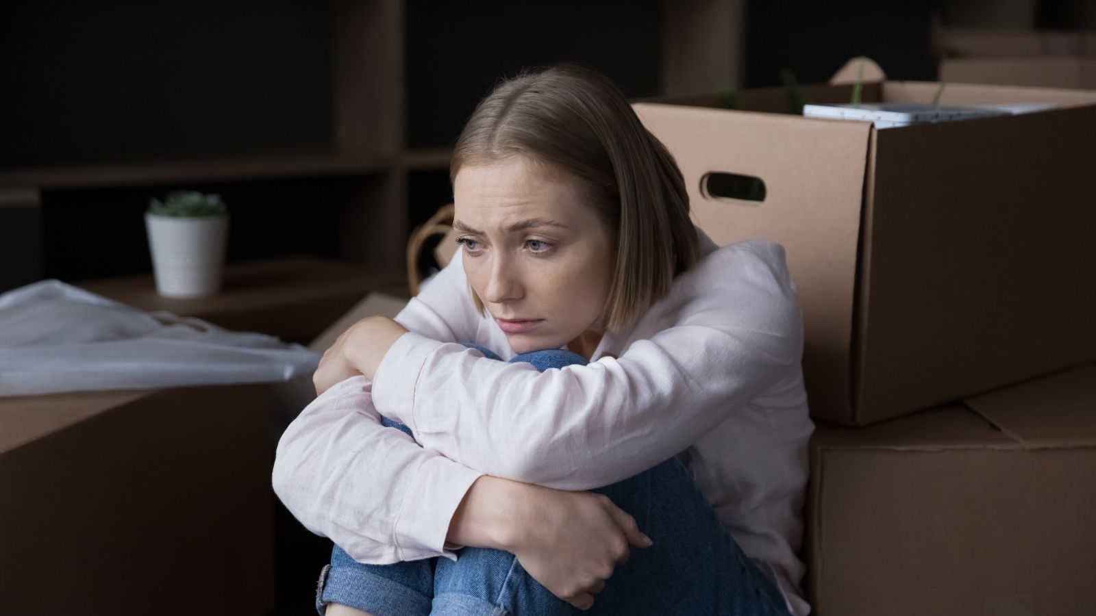 Couple Recently Moved Into An Apartment, But Their Landlord Is Now Warning They May Have To Move Out On Short Notice upset woman sitting on the floor next to moving boxes