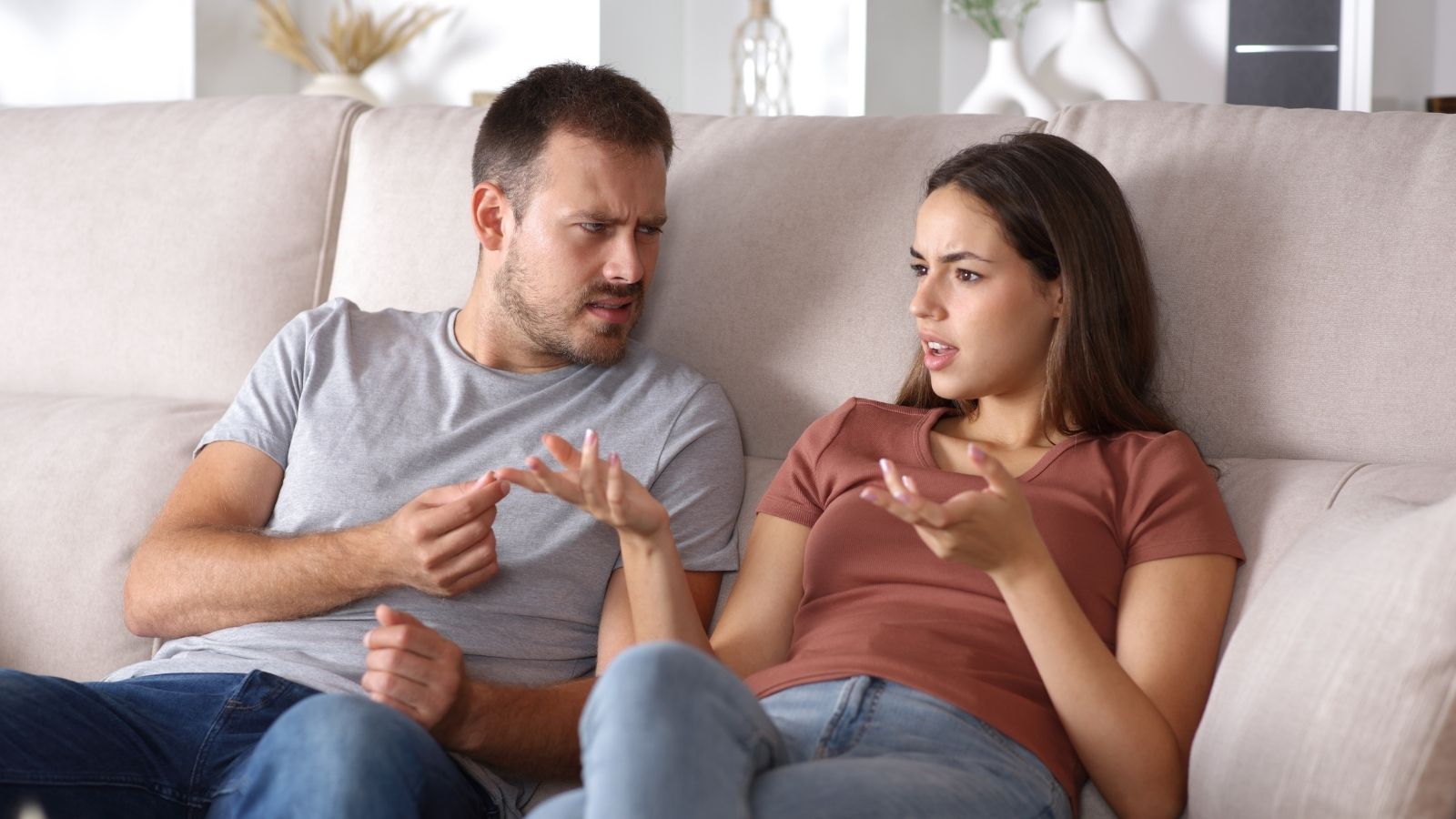 Young Woman Talks To Her Late Fathers Picture Every Morning, But Her Boyfriend Wants Her To Call Him “Dad” couple sitting on the couch arguing