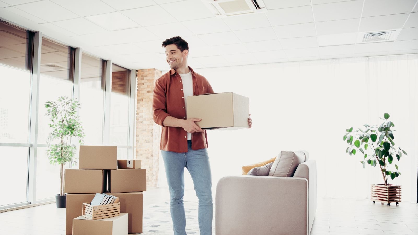 Renter Plans To Move Out Early, But Isnt Sure If He Should Let His Landlord Access The Apartment Before The Lease Ends man holding a moving box
