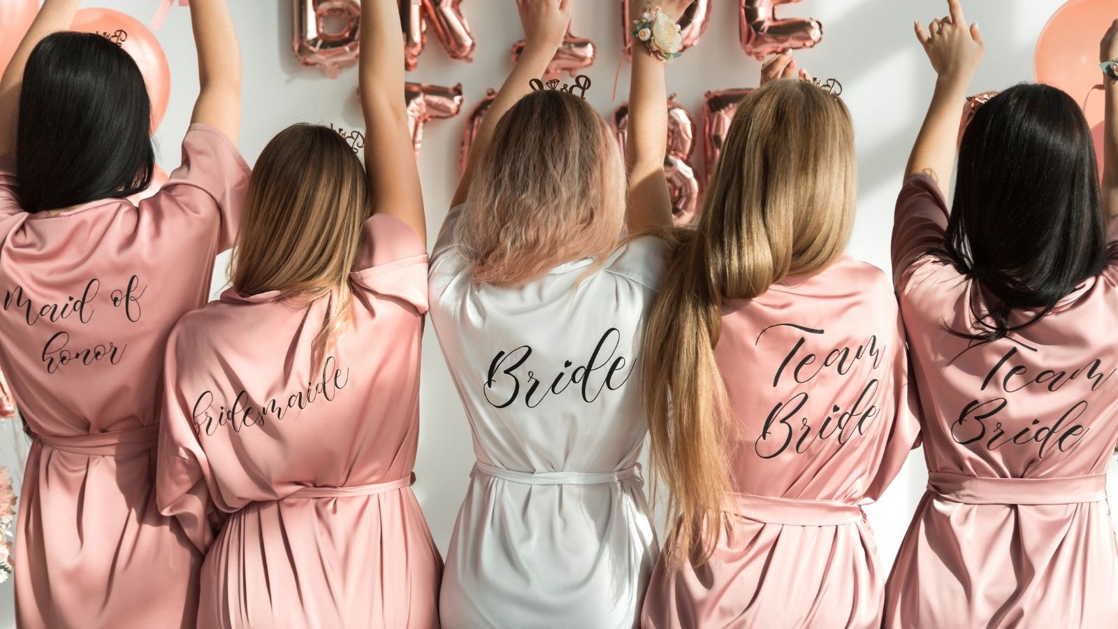 She Was Kicked Out of the Bachelorette Trip and Wedding Party Over a Rumor — Now She Wants Her Expenses Back bride and bridesmaids in silk robes at a bachelorette party