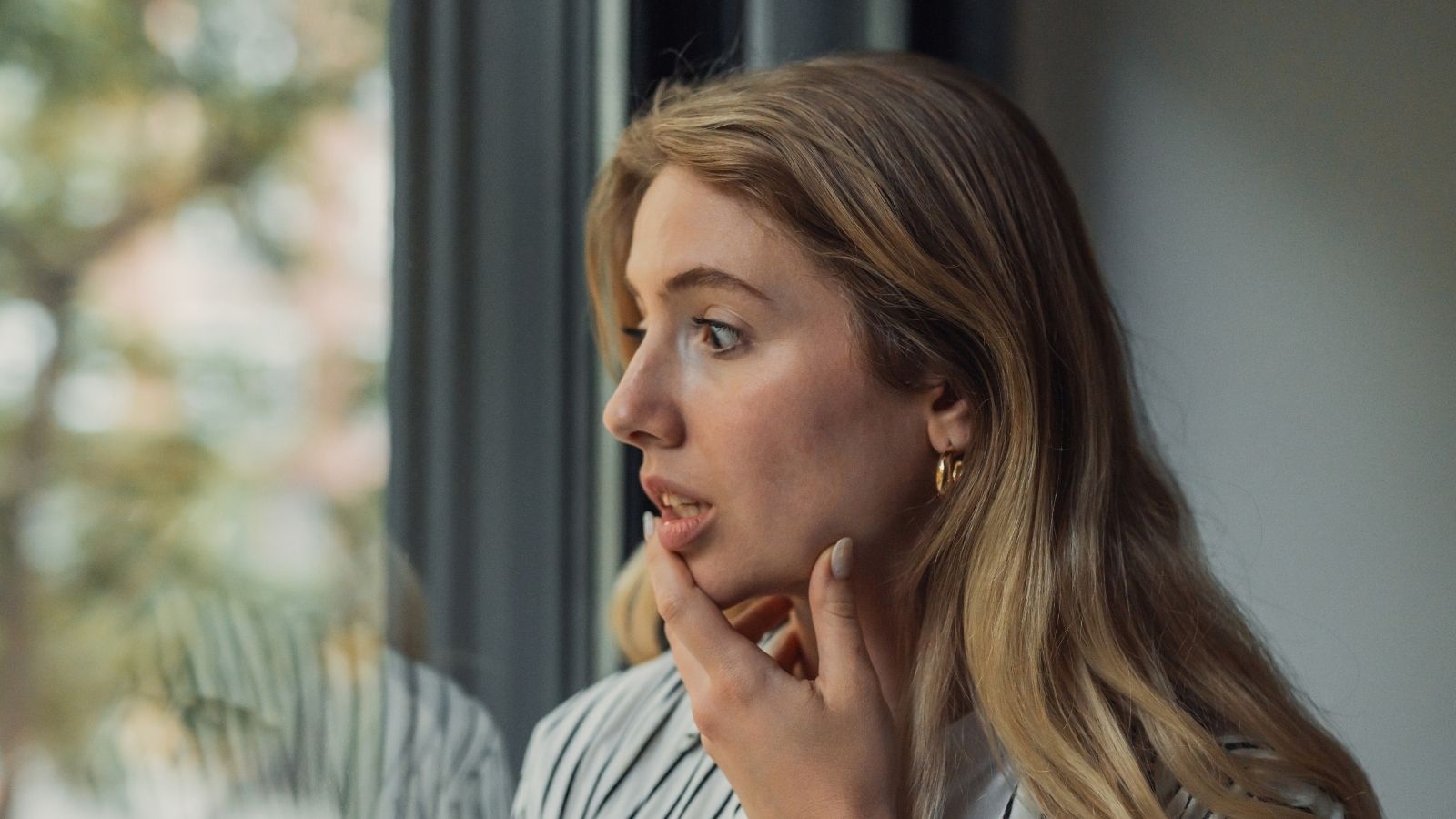 She Watched Her Downstairs Neighbors Blast Bass Until 2 AM Every Night—Then Scheduled Her Balcony Pressure Washing Day upset woman looking out the window