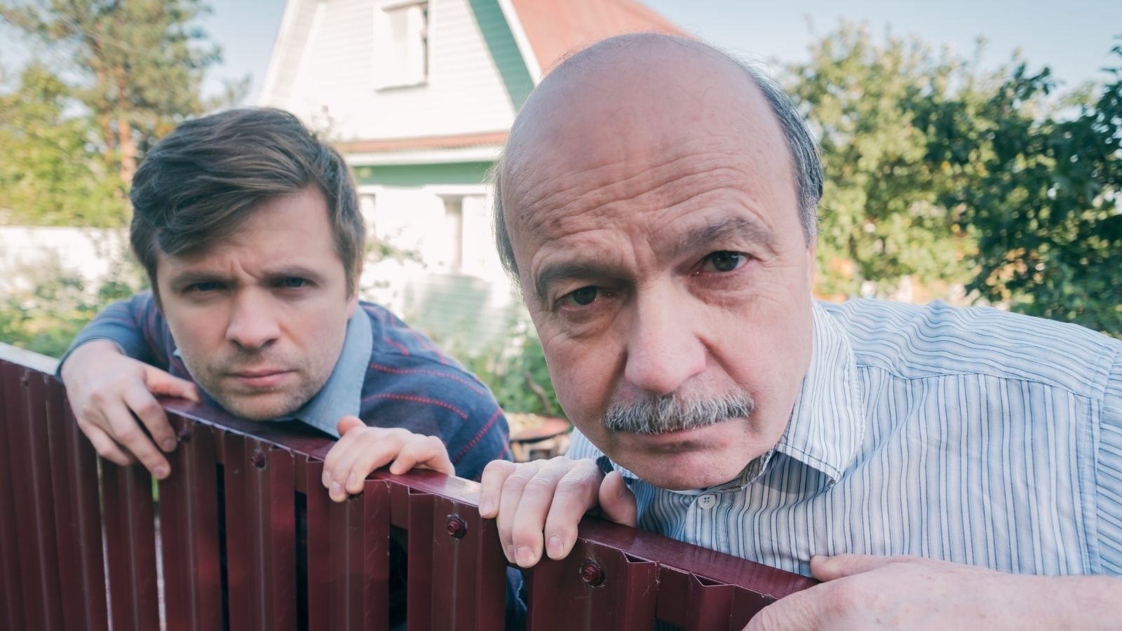 They Erected a 14 Foot Elevated Sun Deck Overlooking His Yard—Then Were Forced to Demolish It After Code Enforcement Arrived two men looking over a fence