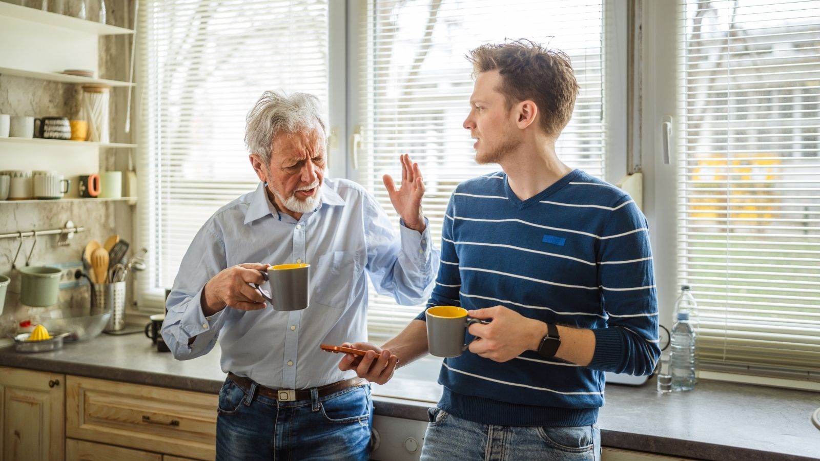 father and son arguing while holding coffee cups