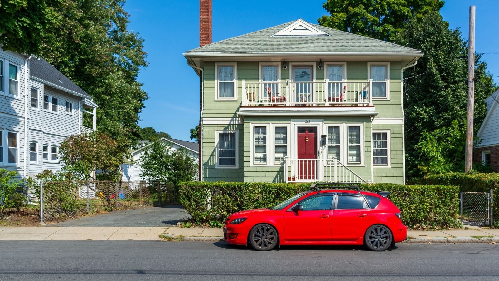 His Neighbors Complained About Where He Parks, But He And His Wife Disagree On How To Respond red car parked on the street in front of a green house