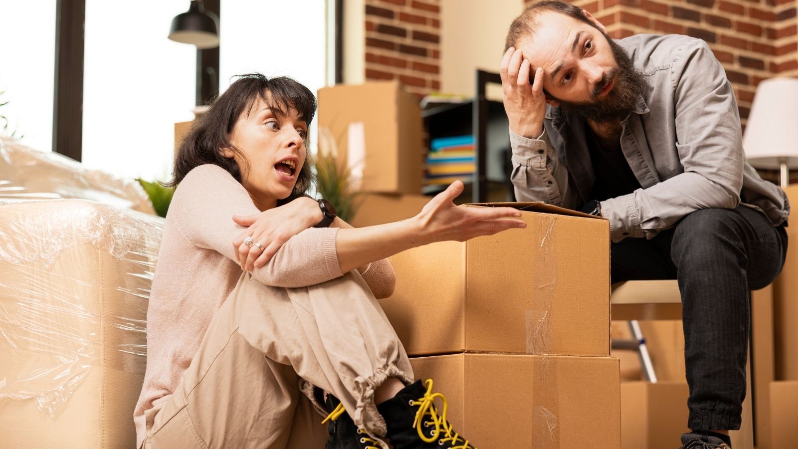 They Spent $40,000 Moving Across Town to Escape Toxic Neighbors—Then Discovered Their New Next Door Neighbor Is A Known HOA Litigation Terrorist frustrated couple surrounded by moving boxes
