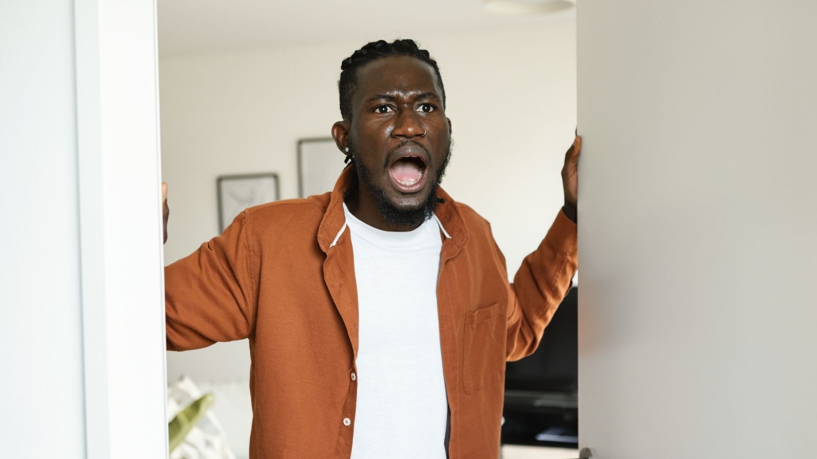 shocked and upset man standing at his front door