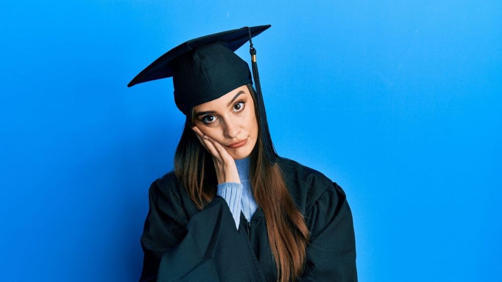 upset teenage girl in a graduation cap and gown