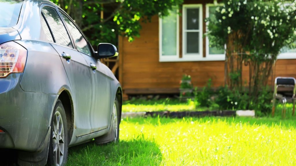 car parked in the grass in front of a house