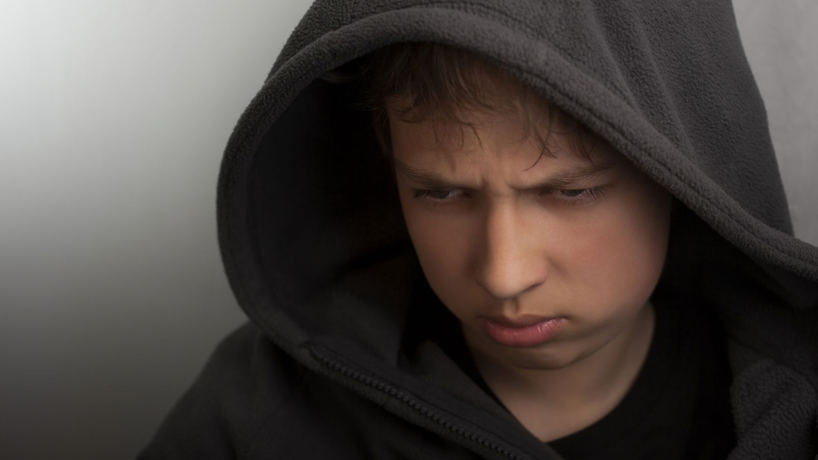 She Moved Back Home During Covid For Safety, But Her Dad Has Made Life Harder Than It Ever Was At School sad teenager in a black hoodie