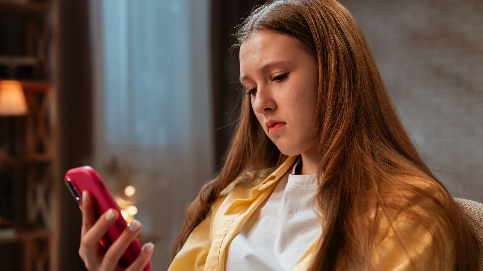 She Responded To Her Dads Text With Just A Thumbs Up, But He Got Furious That She Didnt Say More teenage girl looking at her phone