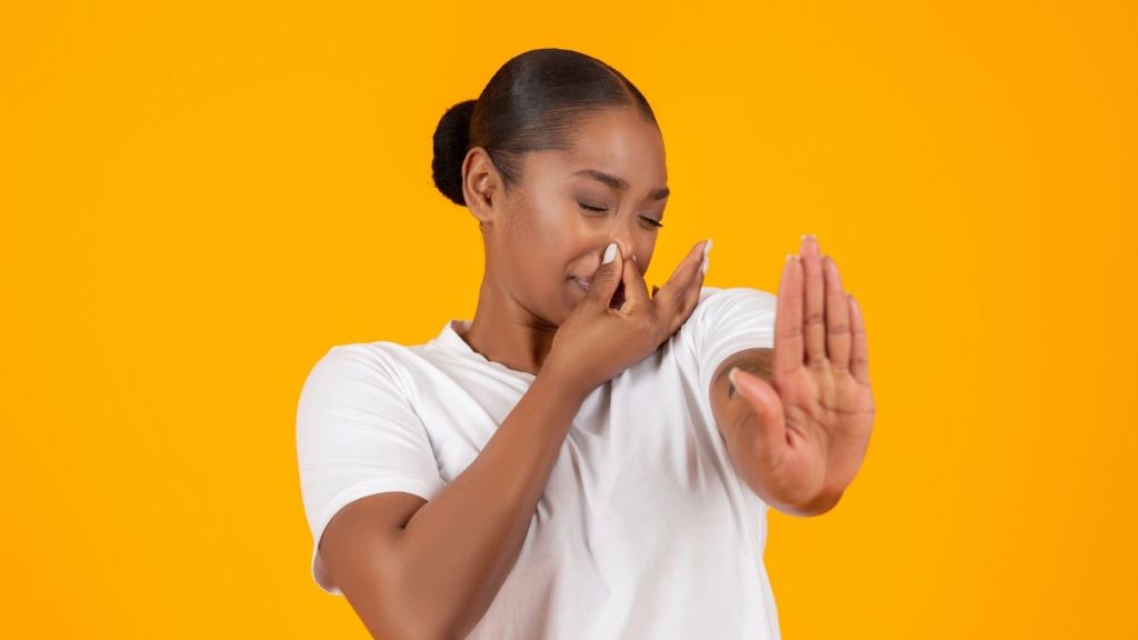 woman holding her nose because of a bad smell