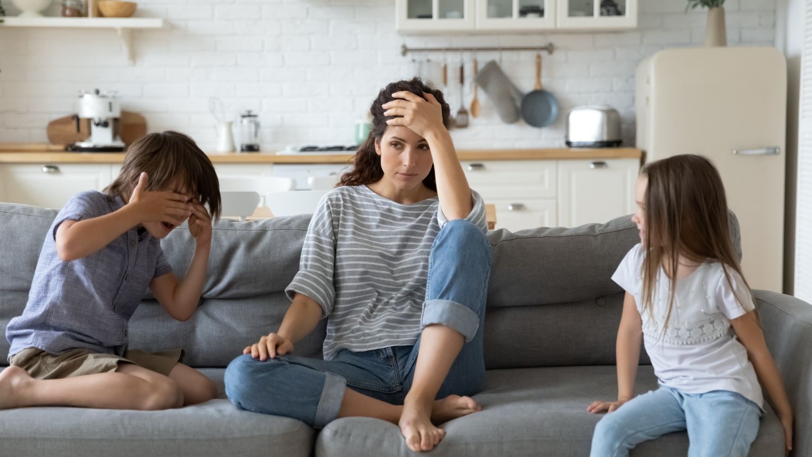 She Wanted To Set Up A Playdate After Their Kids Became School Friends, But The Other Mom Said No sad mom sitting on the couch with two kids