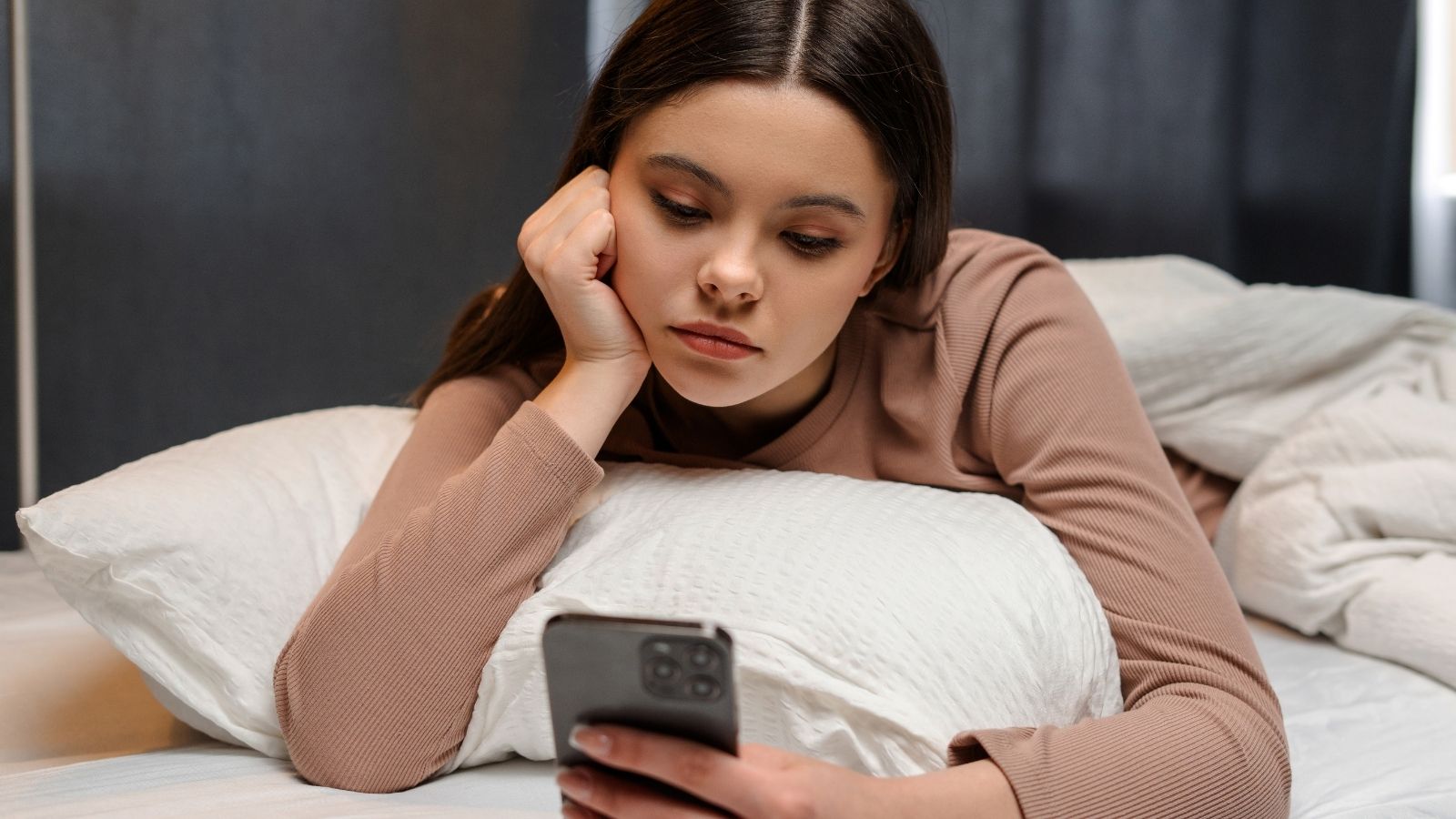 She Poured Her Heart Out, Asking Her Dad To Make An Effort To Be In Her Life — He Brushed Her Off sad teenage girl looking at her phone in bed