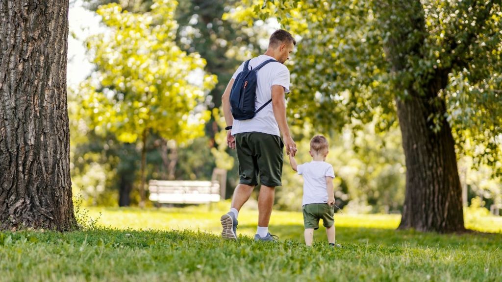 father and son walking in a park