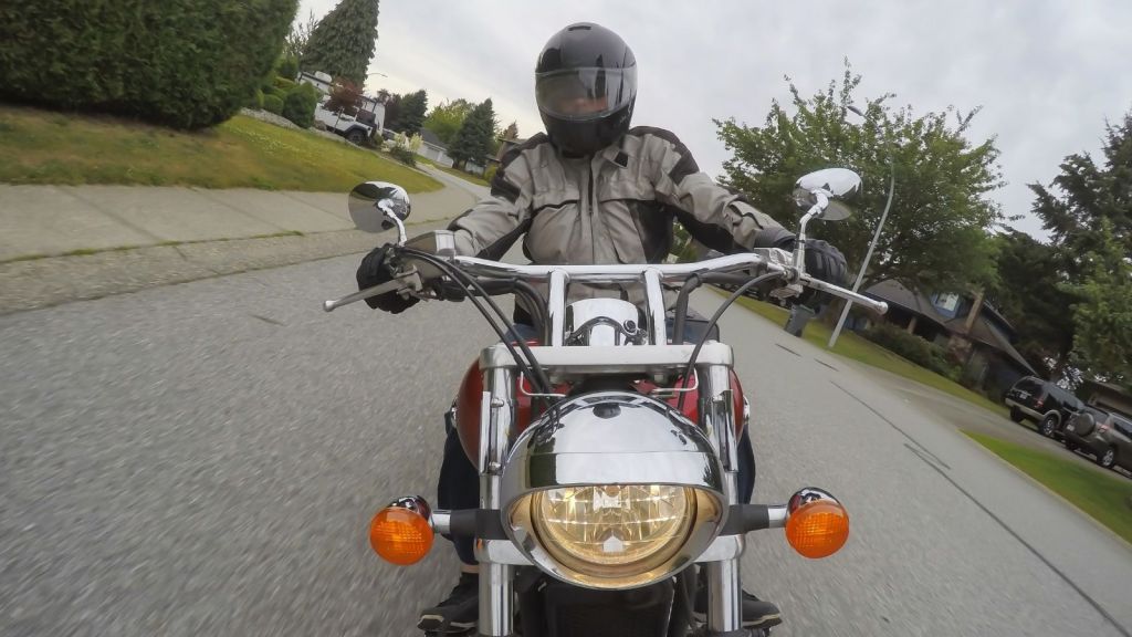 man riding a motorcycle on a residential street