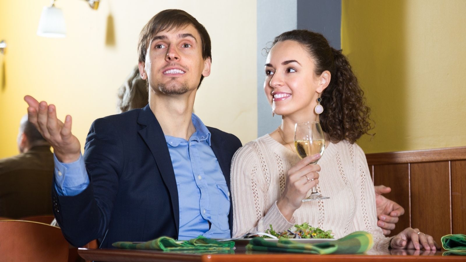A Couples Favorite Restaurant Feels Completely Different Under New Management — And Not for the Better couple trying to get waiter's attention at a restaurant
