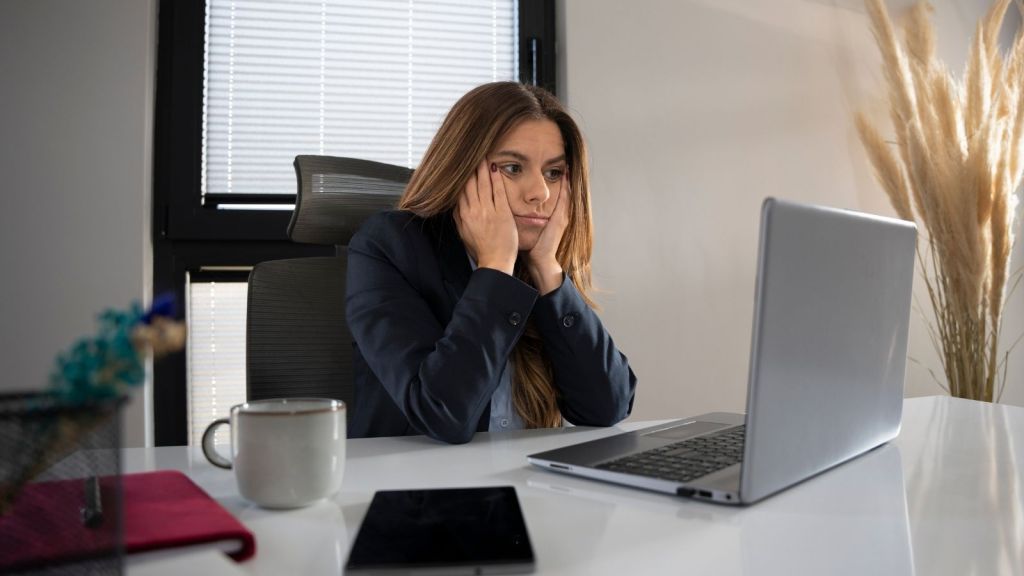 overwhelmed business woman looking at a computer