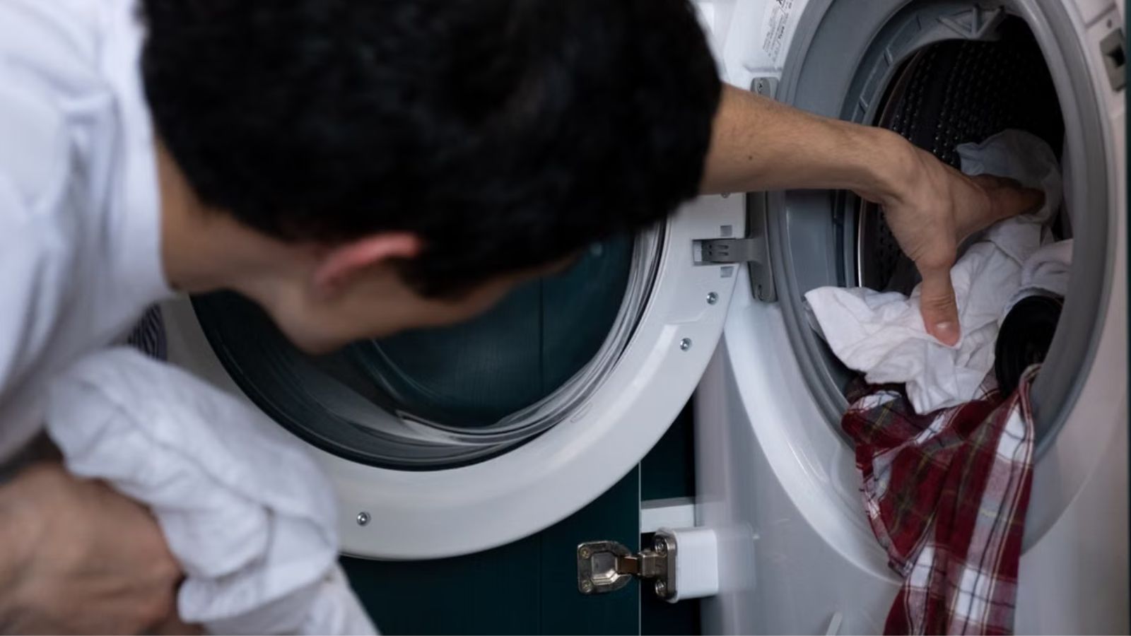 Man taking off clothes from the washer