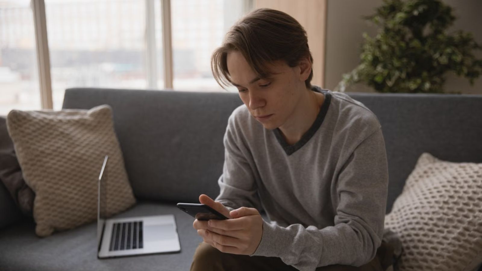 Teenager looking at his phone with a serious face