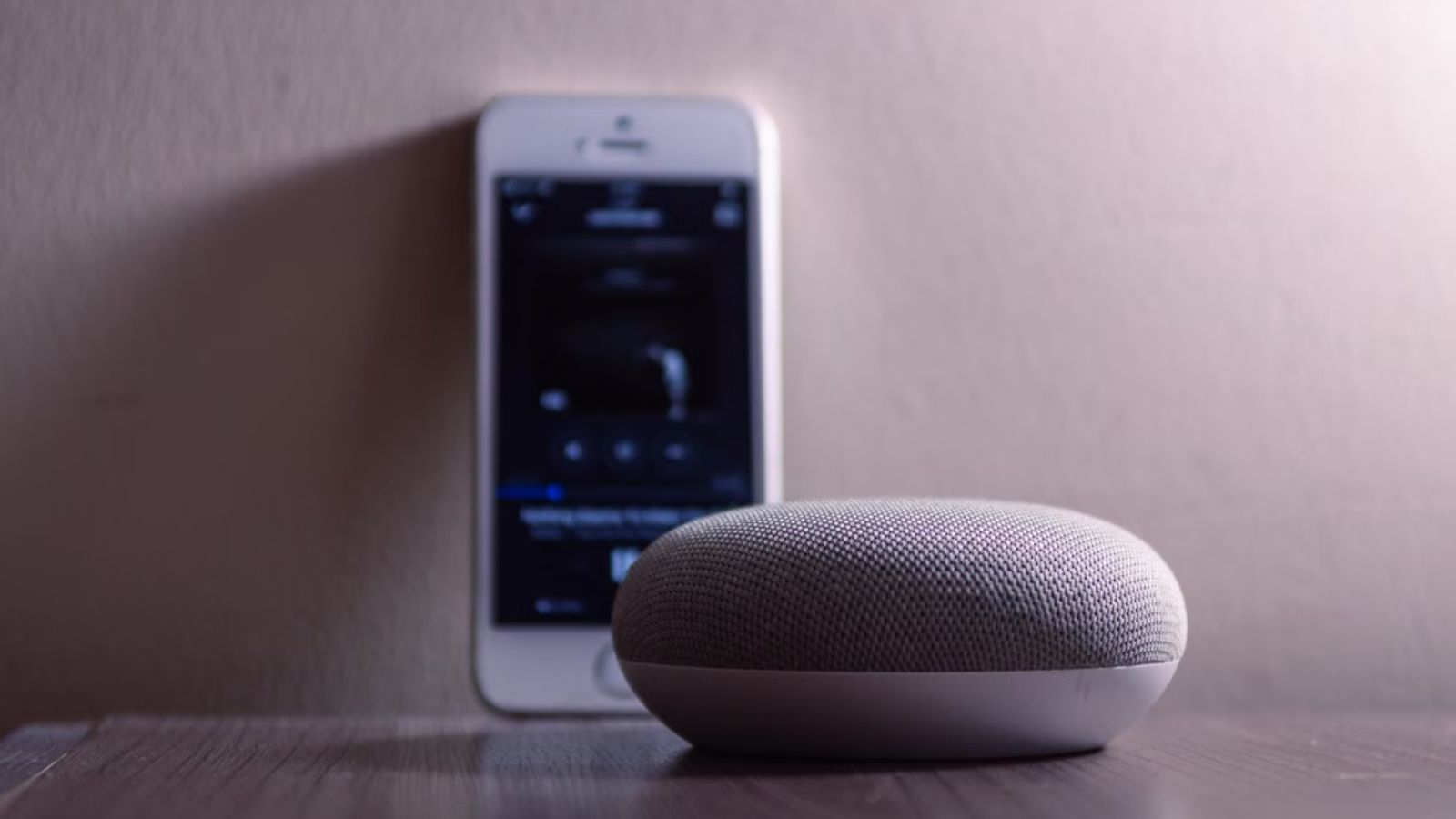 A phone and speaker placed on the surface of a desk