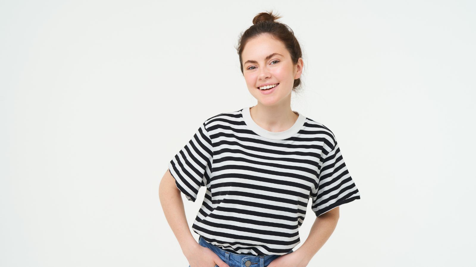 Woman with a pretty smile is wearing stripes shirt and jeans