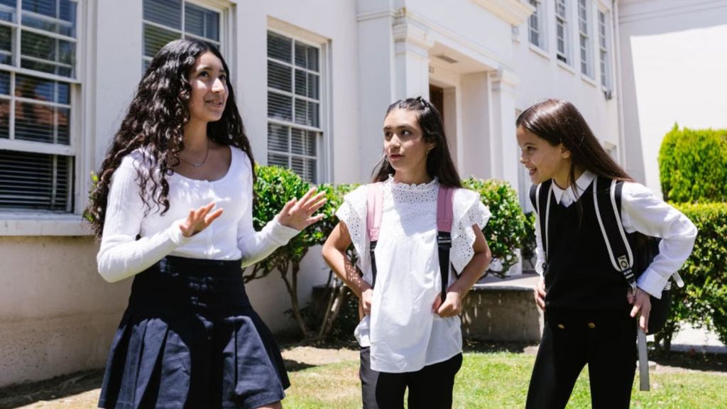 Teenage girls in school uniform talking outdoors