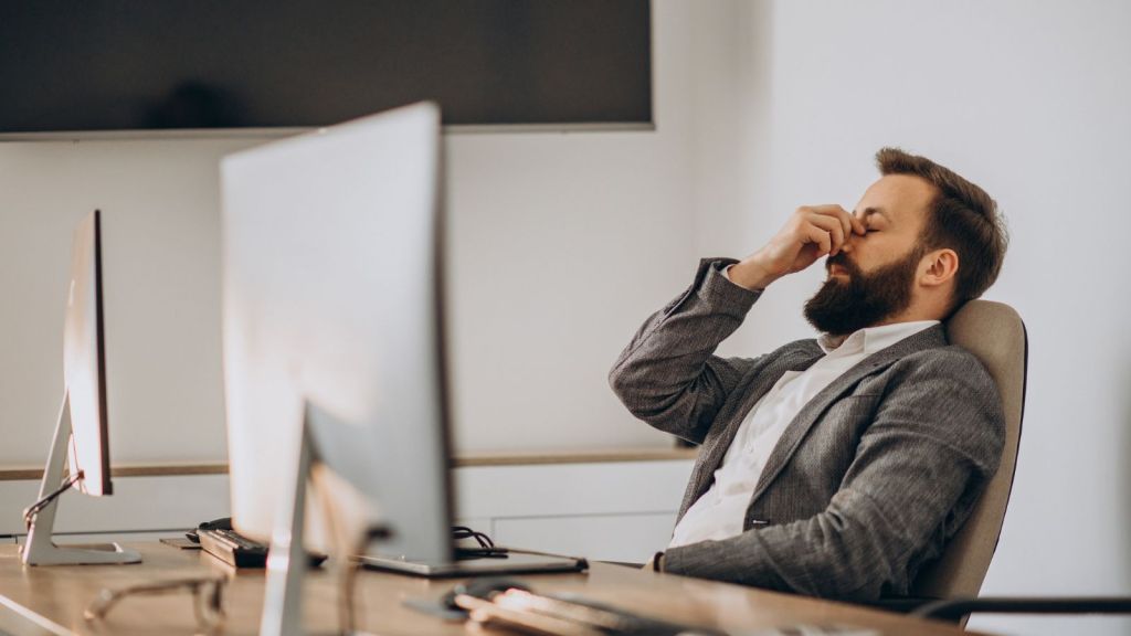 Man in business suit feeling tired in the office