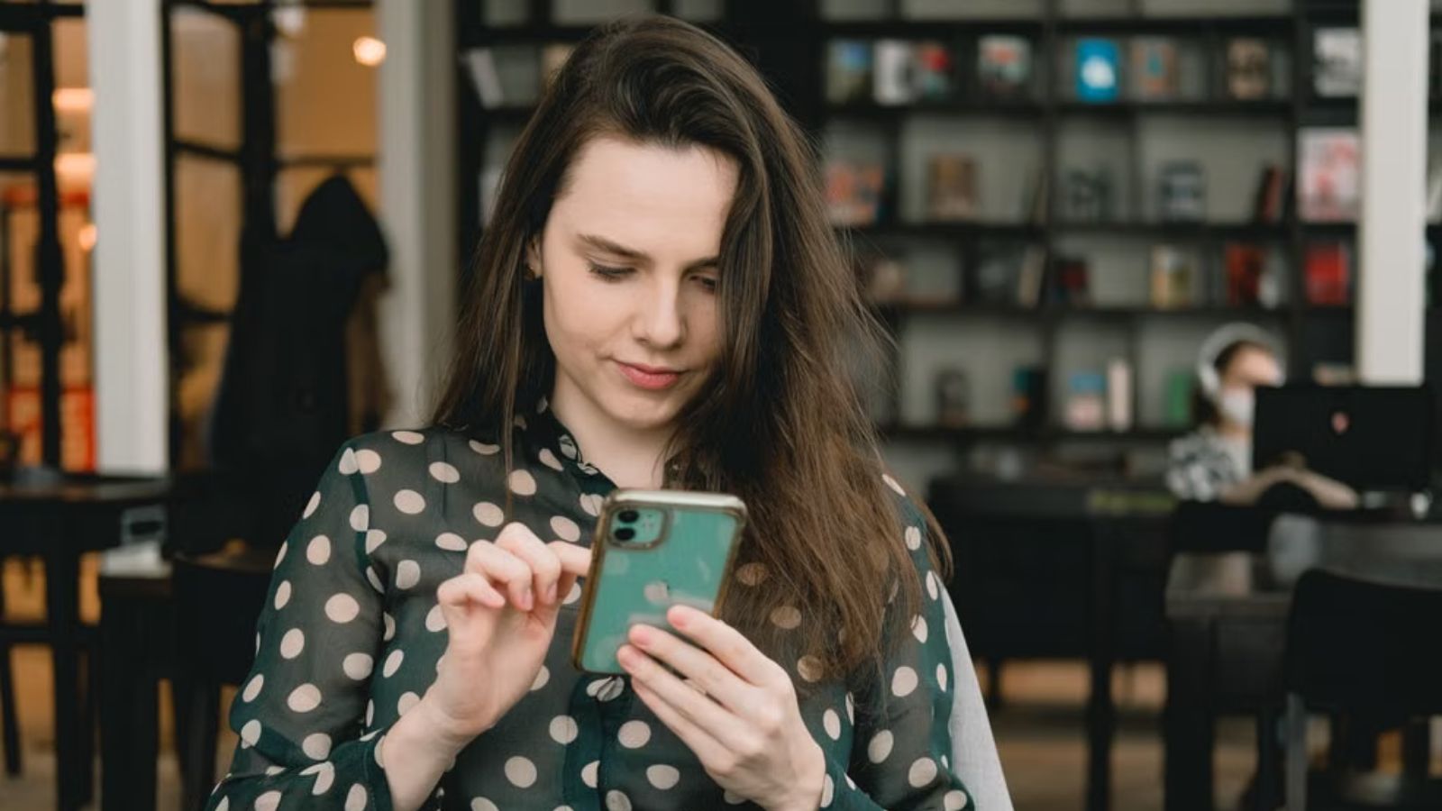 Young lady looking at and engaging with her phone