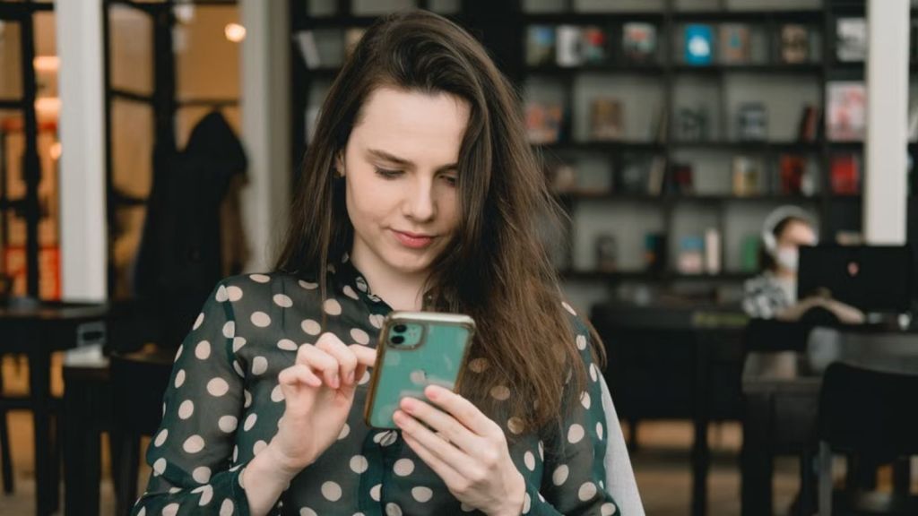 Young lady looking at and engaging with her phone