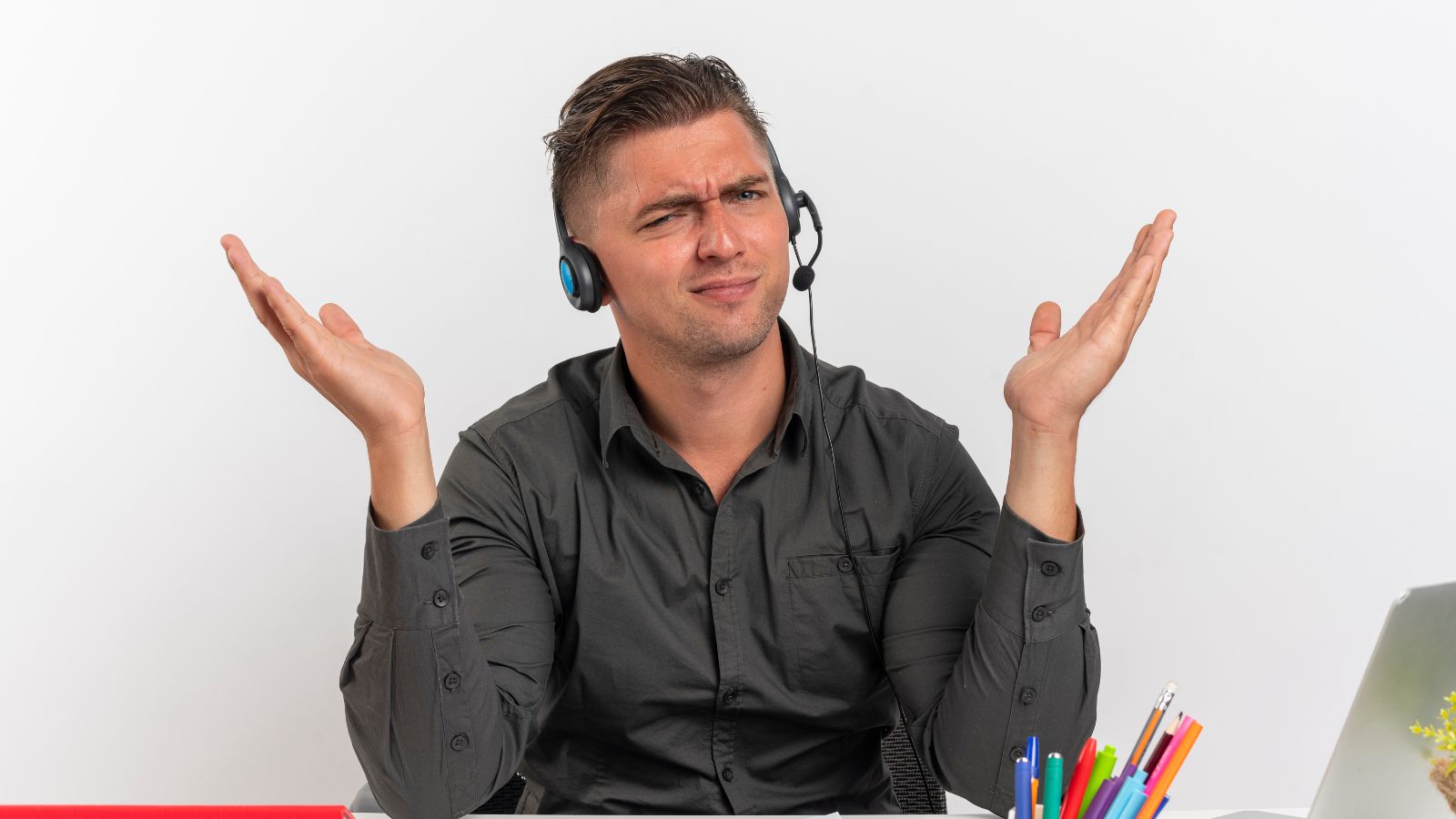 She Tried to Help a Customer Find His Package — Then They Spent Minutes Arguing Over Zed vs. Zee Man with a headset in the office feeling confused with his hands raised on his shoulders