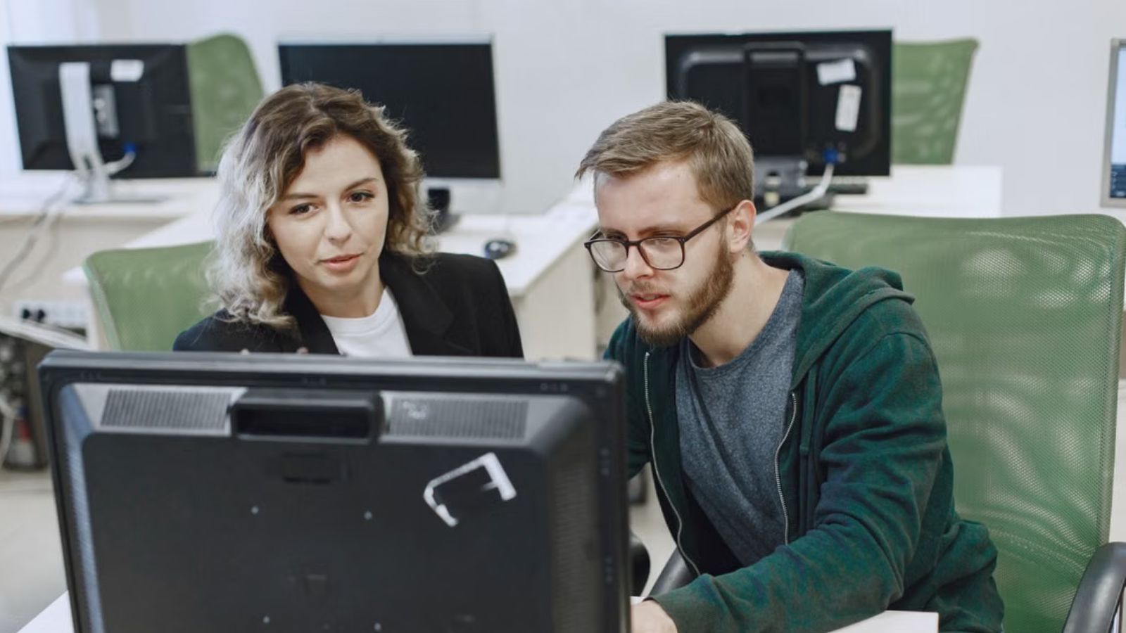 Man and woman looking at a computer screen in the office