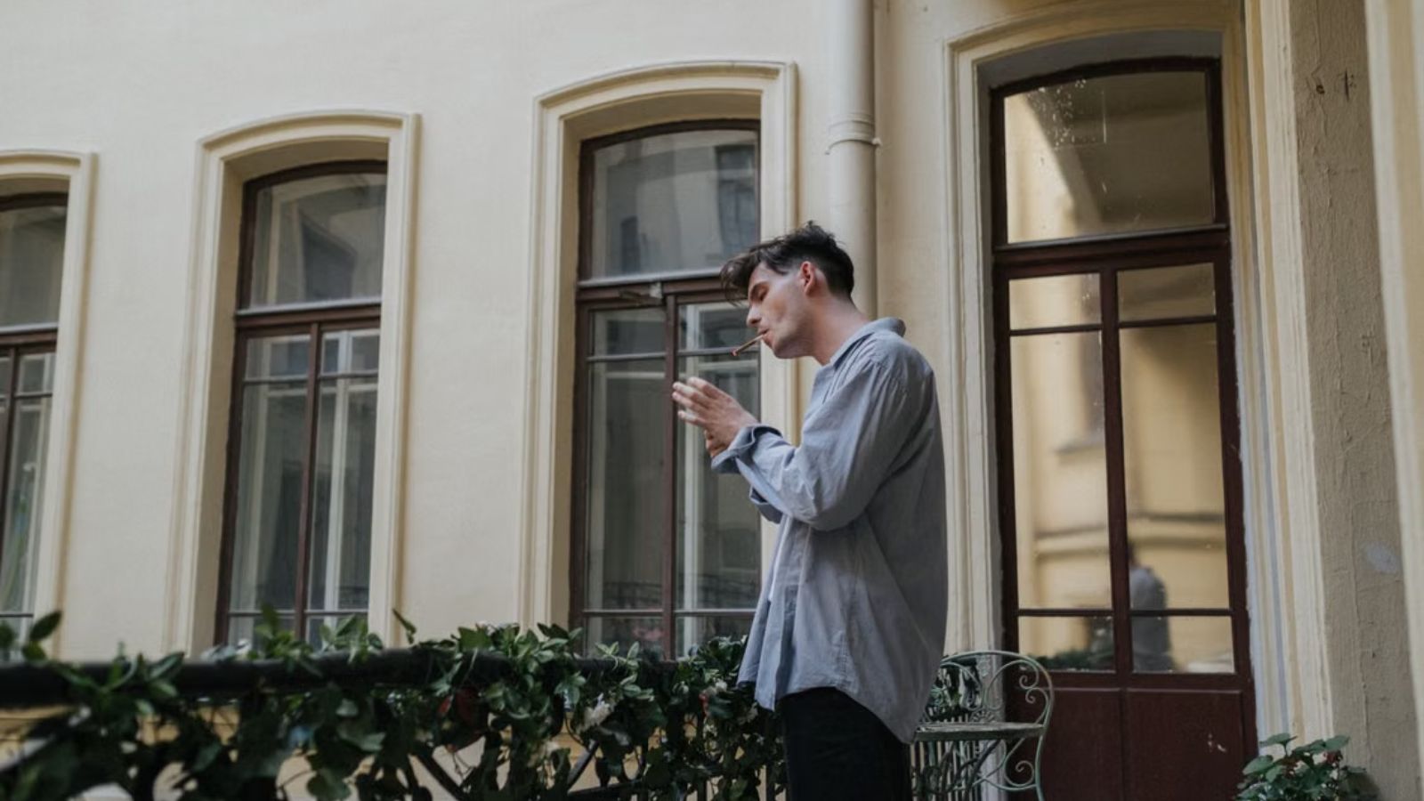 Man smoking on the the balcony of an apartment building