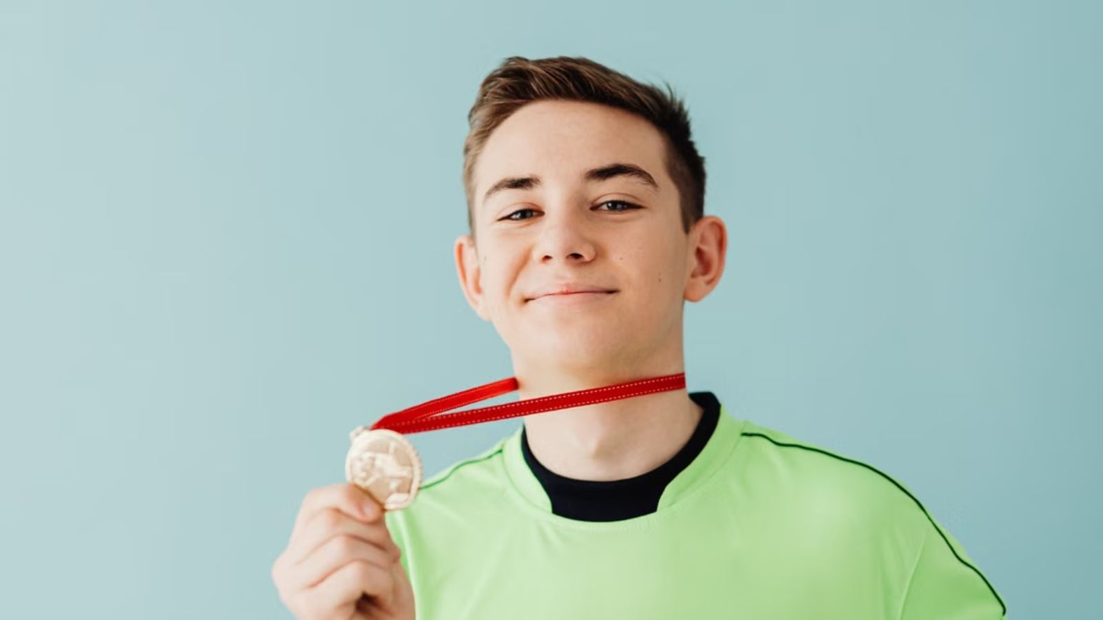 He Earned His First Track Medal and Wanted a Meal with His Dad—Who Hijacked the Night into an Obligatory Bonding Session with His New Family Teenage boy flexing his medal and smiling